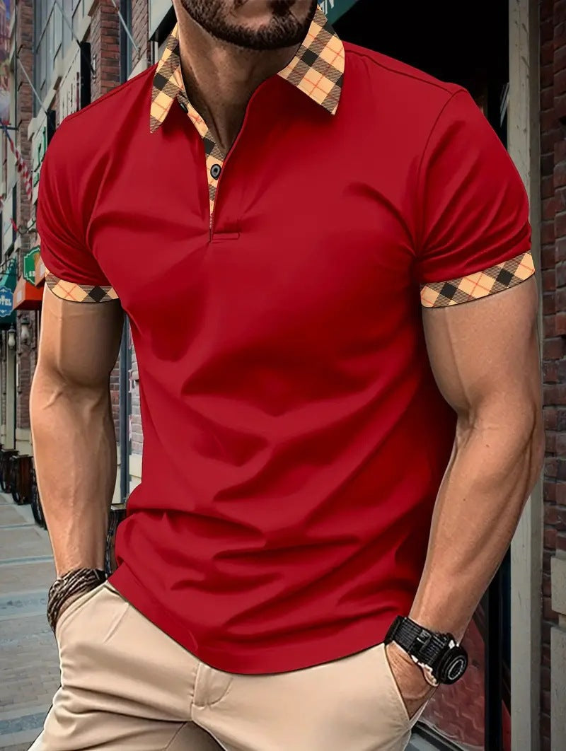 Man wearing a red polo shirt with checkered collar and sleeve ends, standing against an urban background.