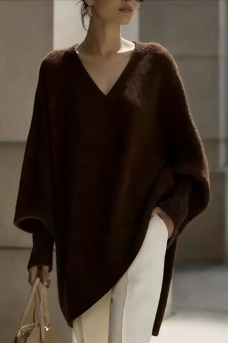Person wearing a dark brown poncho in an indoor setting