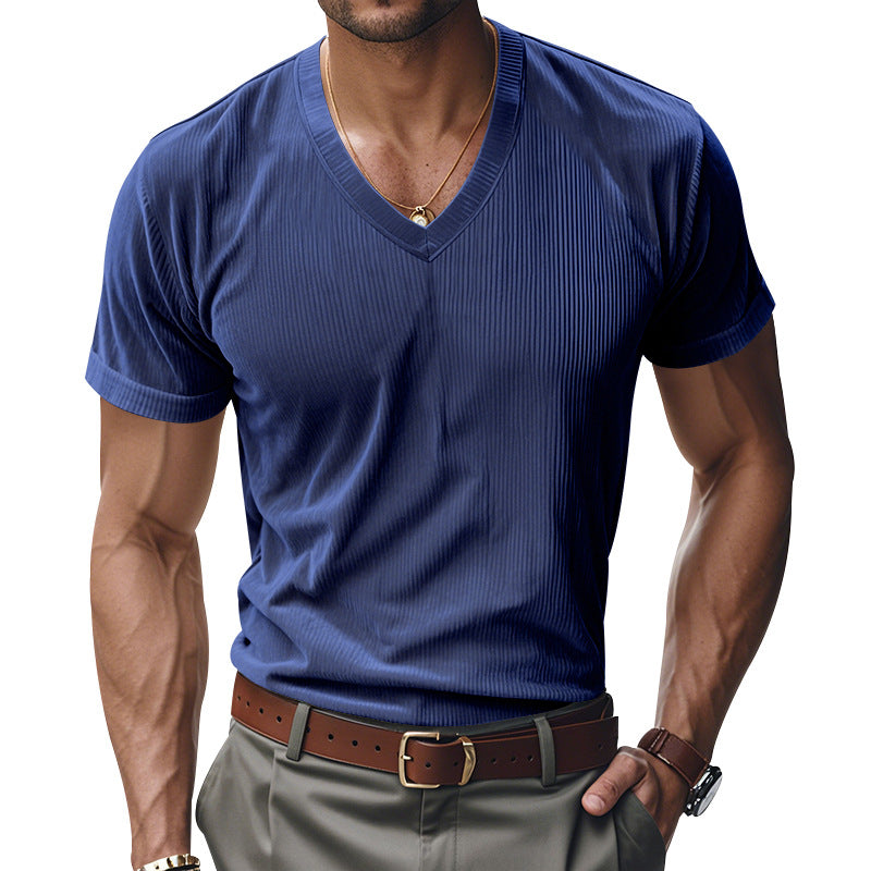 Man wearing a blue ribbed V-neck t-shirt and gray pants on a white background