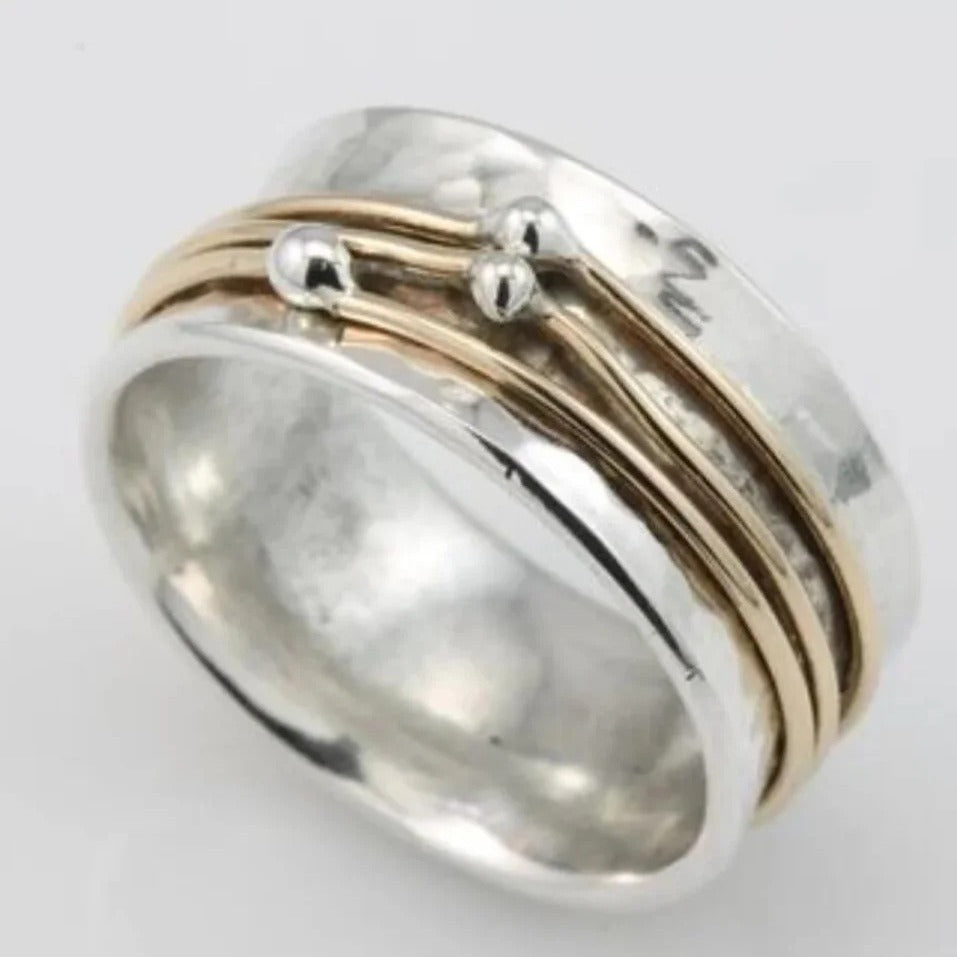 Silver ring with gold accents on a light gray background