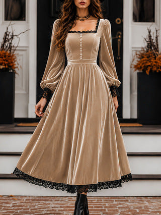 Woman wearing a beige velvet dress with black lace trim standing on steps.