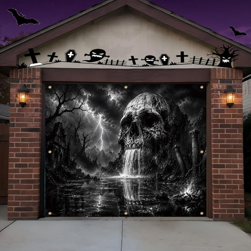 A Halloween-themed garage door mural featuring a large black and white skull in a stormy graveyard landscape with lightning, crosses, tombstones, and bats. The garage is set under a house with brick pillars and lit wall sconces, against a purple night sky.
