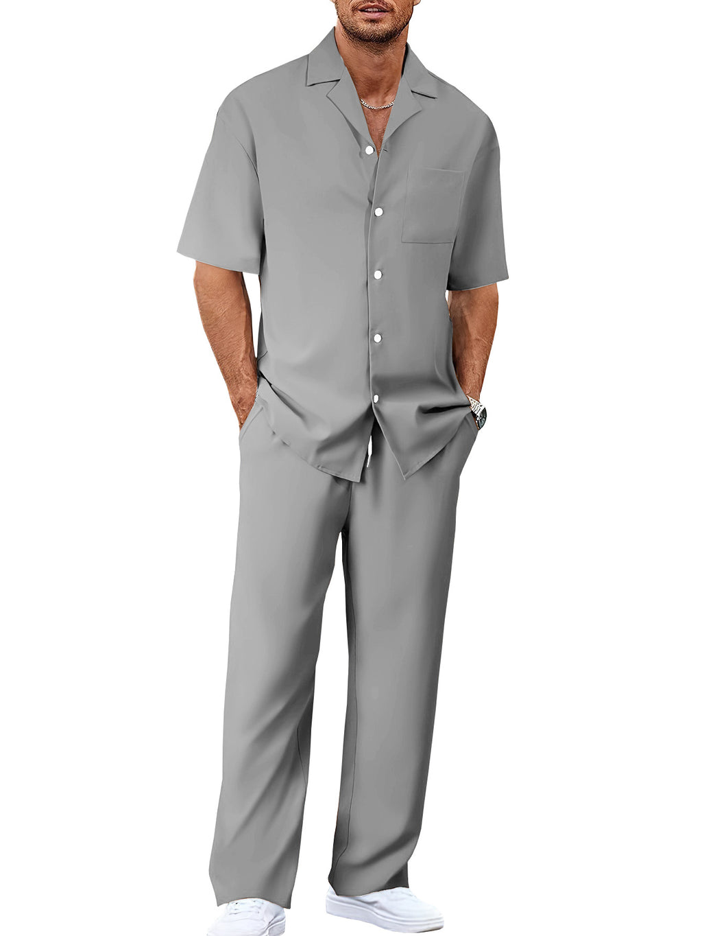 Man wearing a gray short-sleeve shirt and pants set on a white background