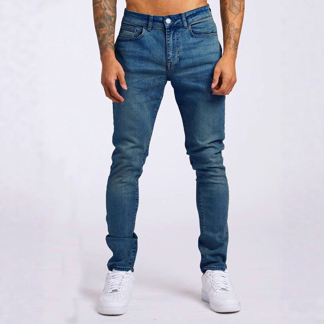 Person wearing blue jeans and white sneakers on a plain background