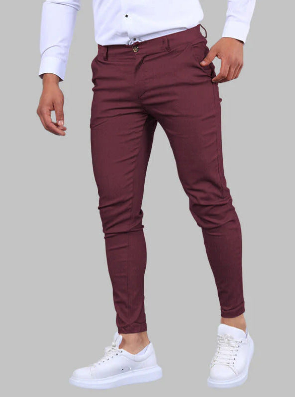 Maroon pants worn by a person on a gray background