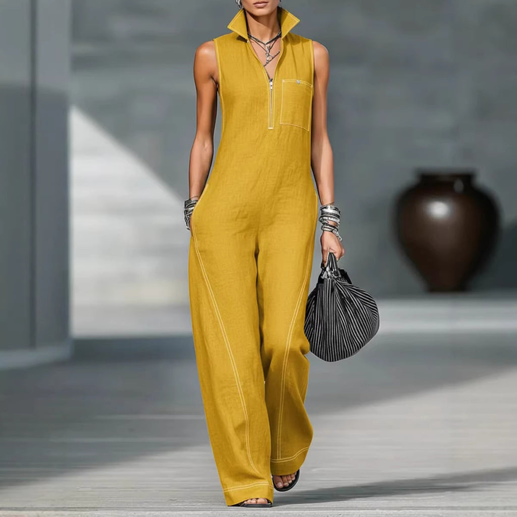Person wearing a mustard yellow sleeveless jumpsuit holding a black handbag.