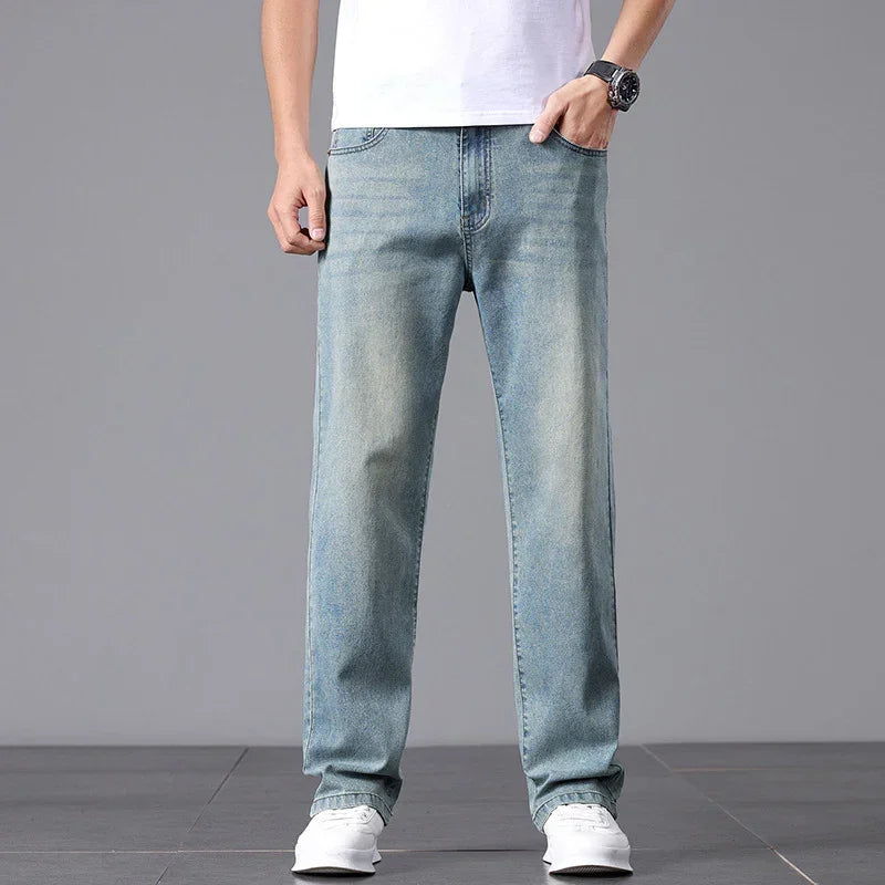 Person wearing light blue jeans on a gray background