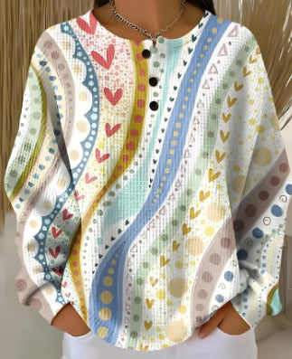 Colorful patterned shirt with heart and geometric designs on a plain background