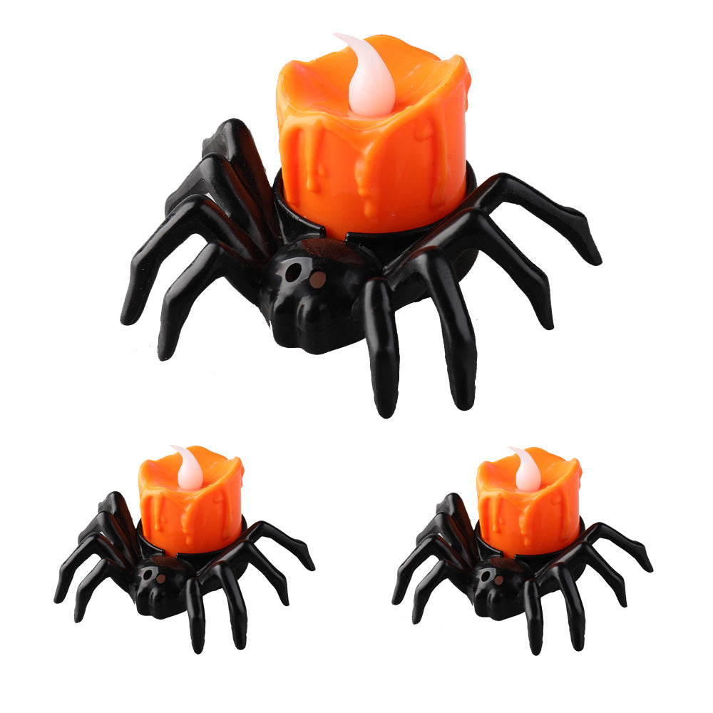 Spider-shaped candle holders with orange candles on a white background