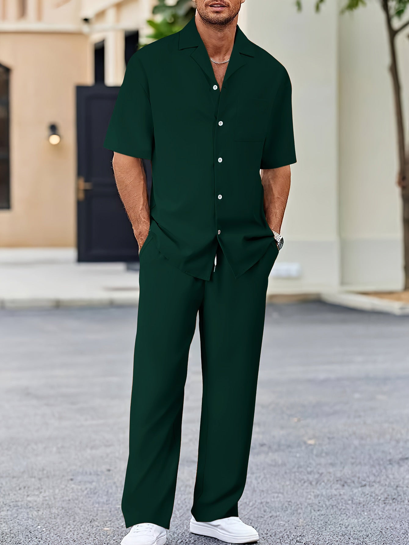 Man wearing a green outfit standing outdoors.