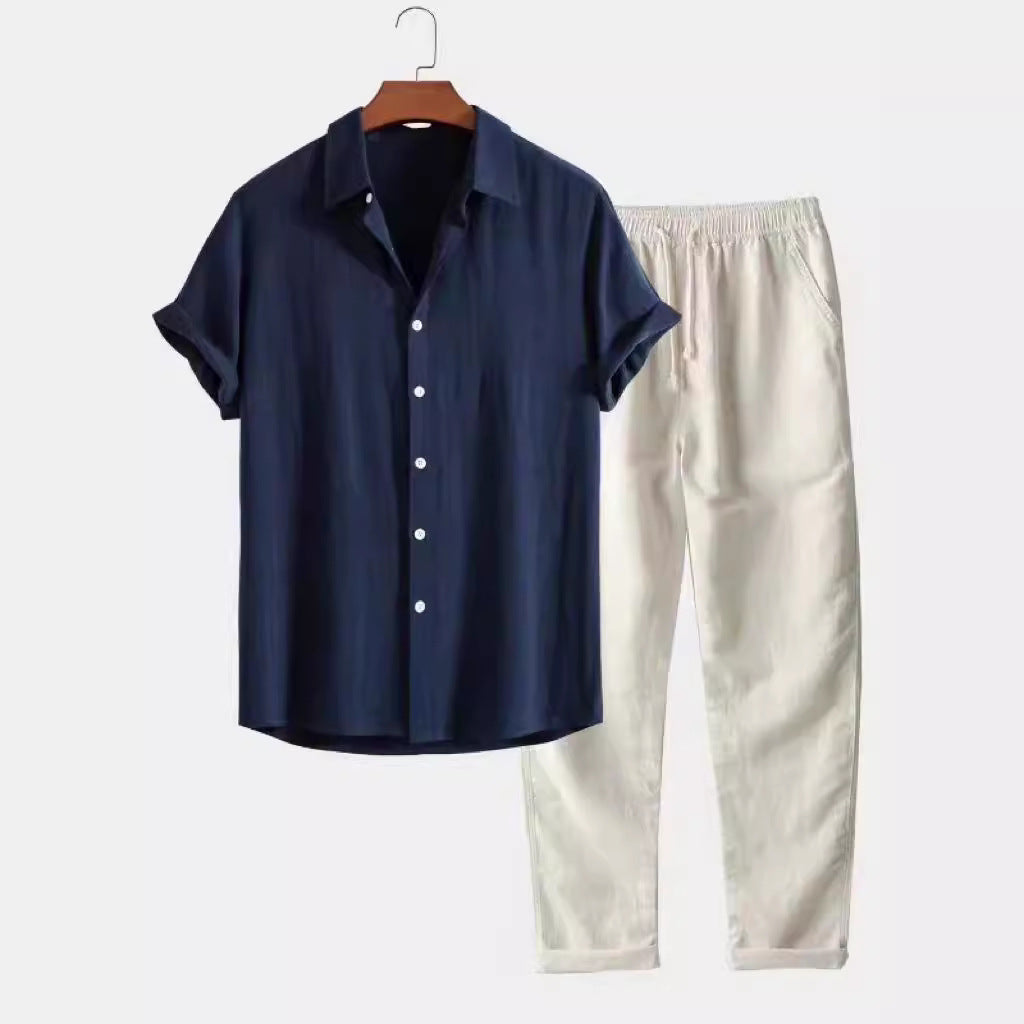 Navy shirt and white pants on a hanger against a white background