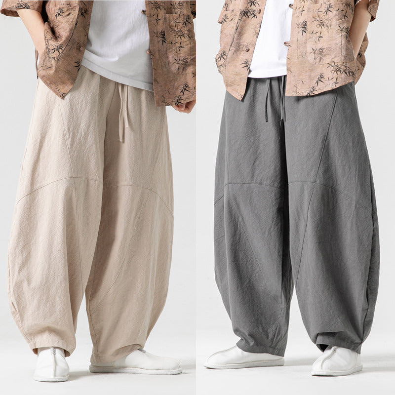 Two pairs of wide-leg pants in beige and gray on a white background