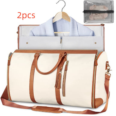 White duffel bag with brown handles and trim, open to reveal clothes, on a white background.