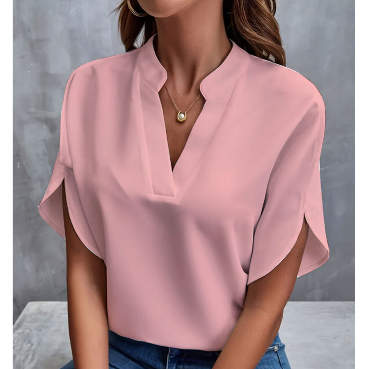Pink blouse worn by a person against a gray background