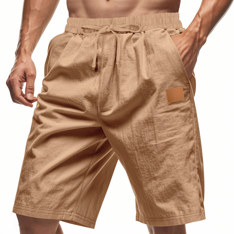 Beige shorts with a drawstring and patch on a white background