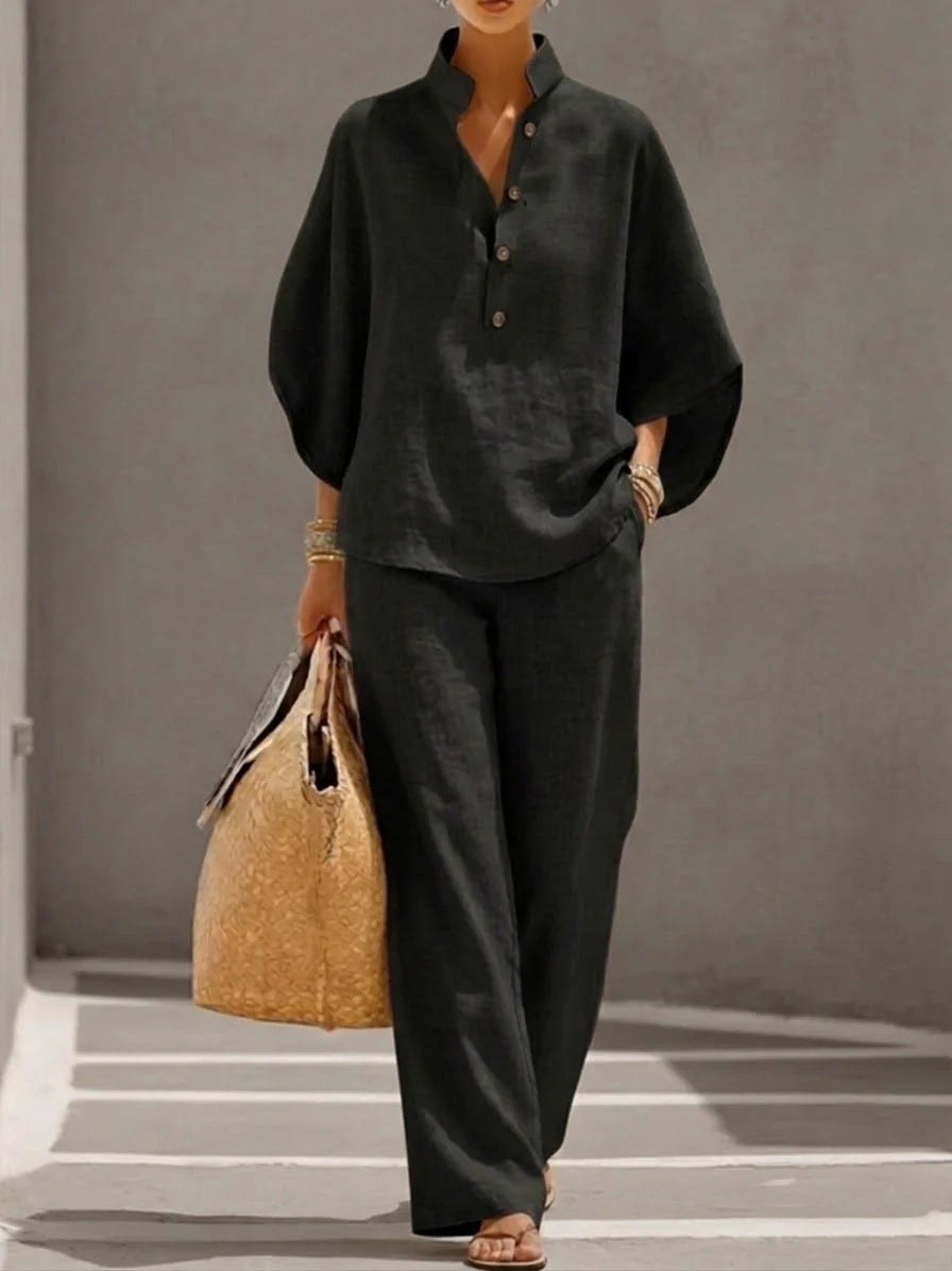 Person wearing a dark outfit holding a woven bag on a neutral background