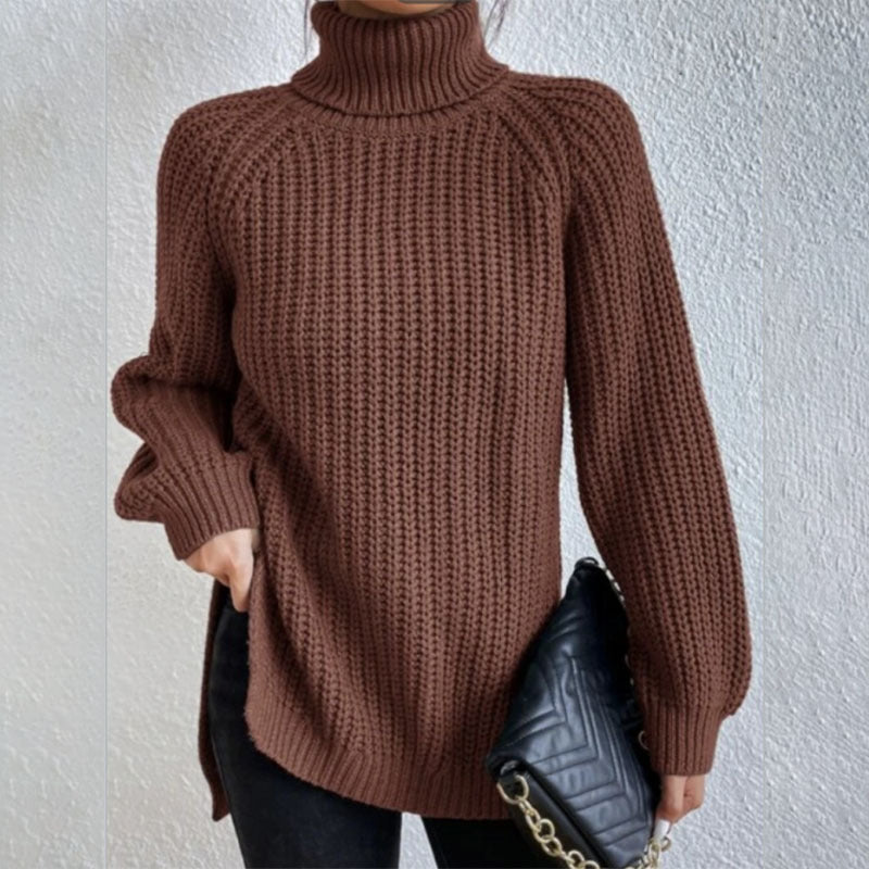Brown knitted sweater worn by a person against a white wall