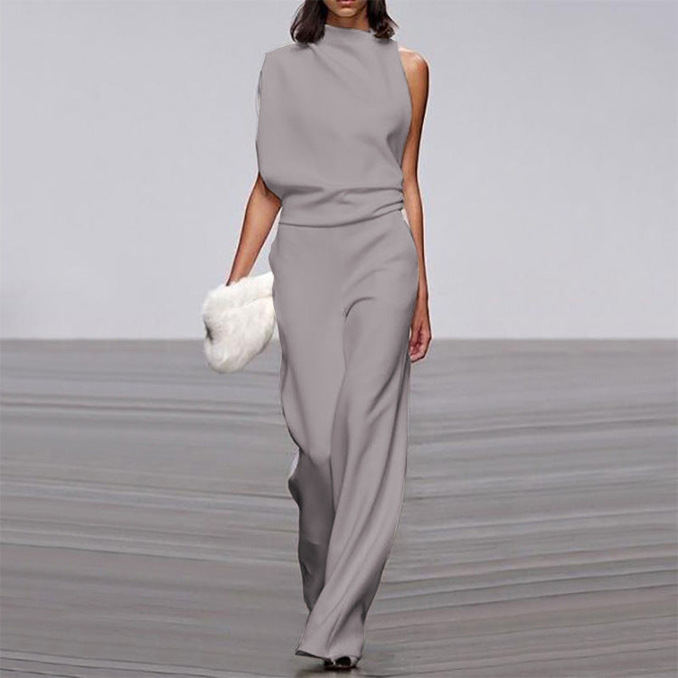 Woman wearing a gray jumpsuit on a plain background