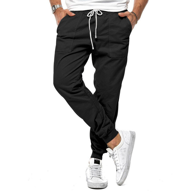 Person wearing black jogger pants with a white background