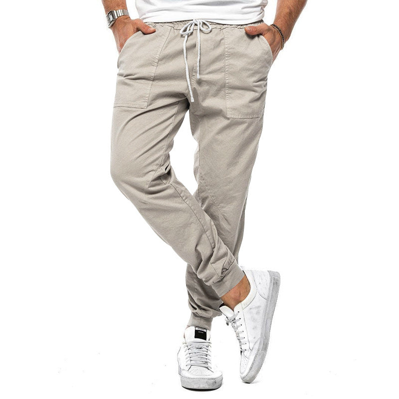 Beige jogger pants worn by a person on a white background