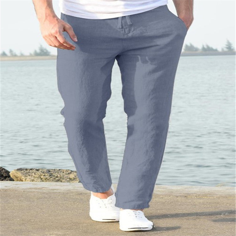 Person wearing gray pants and white shoes by a body of water