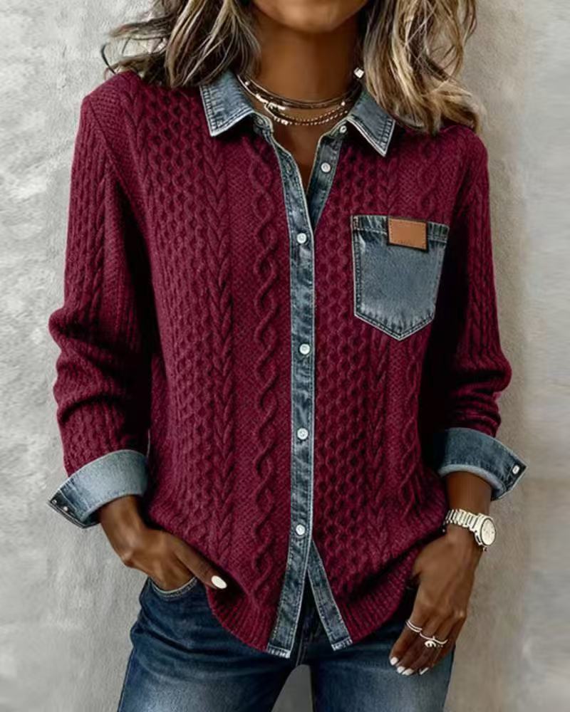 Person wearing a burgundy cable knit cardigan over a denim shirt with a neutral background