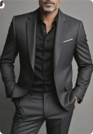 Man wearing a gray suit with a black shirt on a gray background