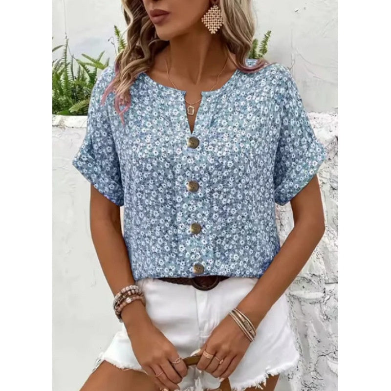 Woman wearing a blue floral blouse with white shorts outdoors.