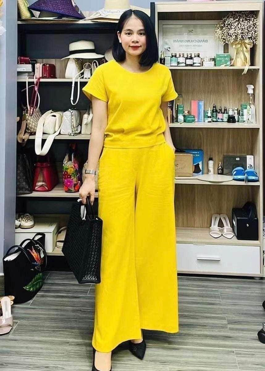 Woman in bright yellow matching set with wide-leg pants, black bag, chic fashion at ZA-Zola UK