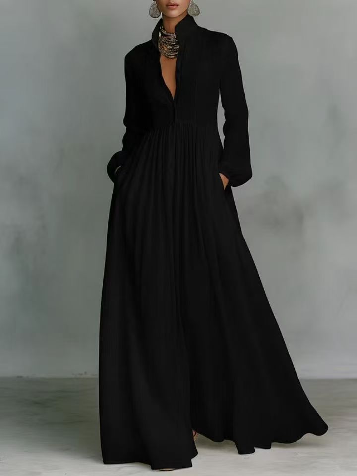 Black long coat worn by a person against a gray background