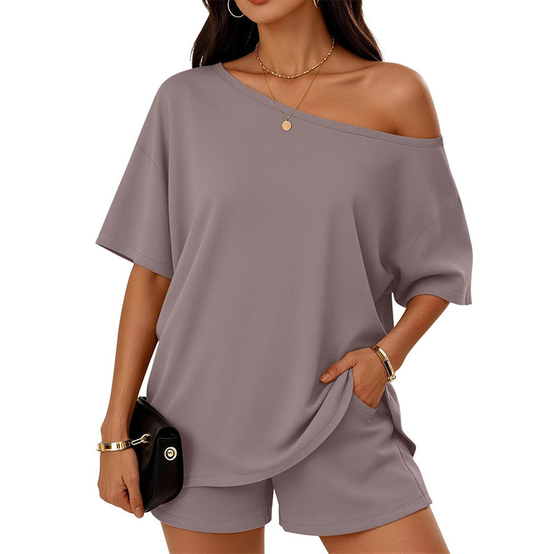 Woman wearing a gray off-shoulder top and shorts set on a white background