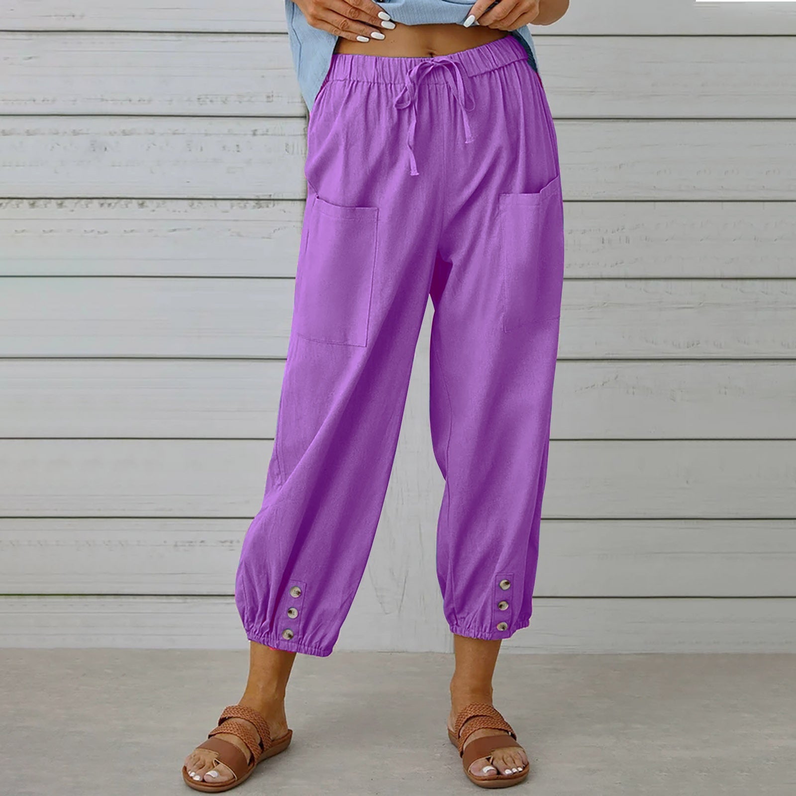 Purple pants worn by a person against a wooden background