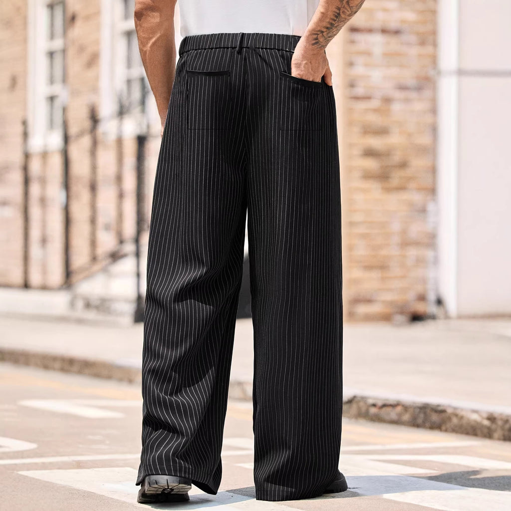 Person wearing black pinstripe pants standing on a street.