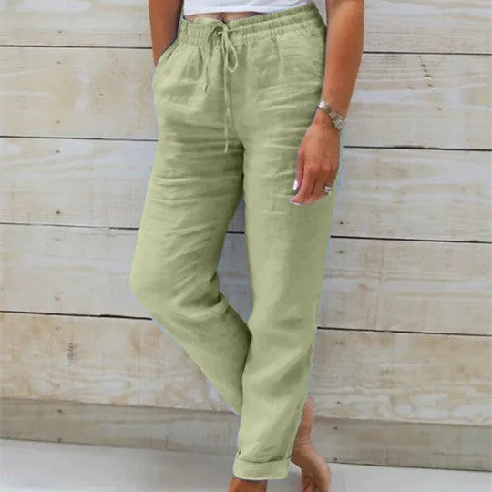 Person wearing light green pants with a wooden background