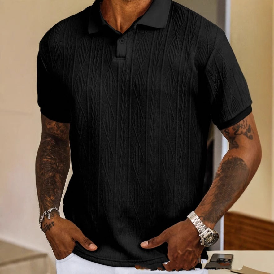 Person wearing a black textured polo shirt with tattoos on arms.