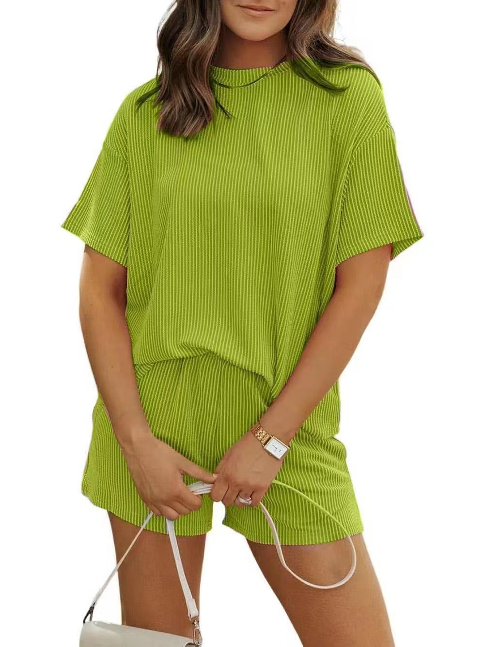 Woman wearing a green ribbed outfit with a white background