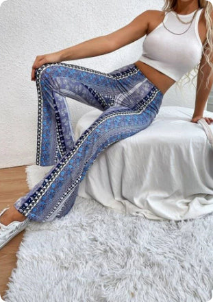 Woman wearing blue patterned pants sitting on a white chair.