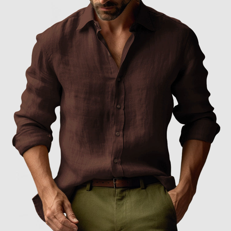 Man wearing a brown button-up shirt and green pants on a light gray background