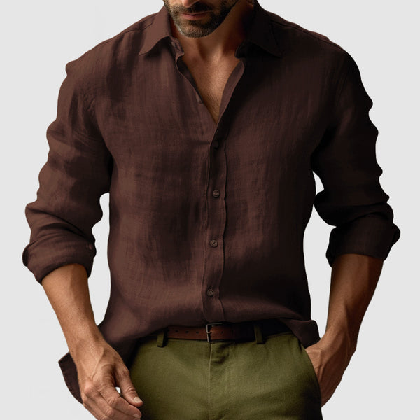 Man wearing a brown button-up shirt and green pants on a light gray background