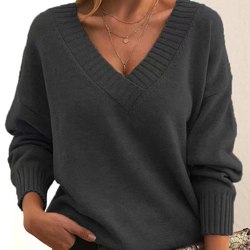 Dark gray sweater worn by a person with a neutral background