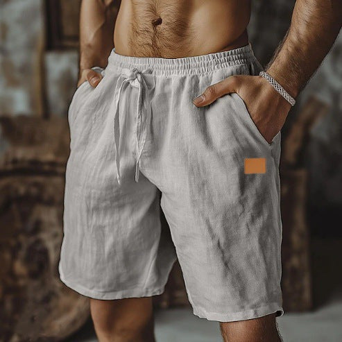 Man wearing light gray shorts with a small orange patch on a blurred background