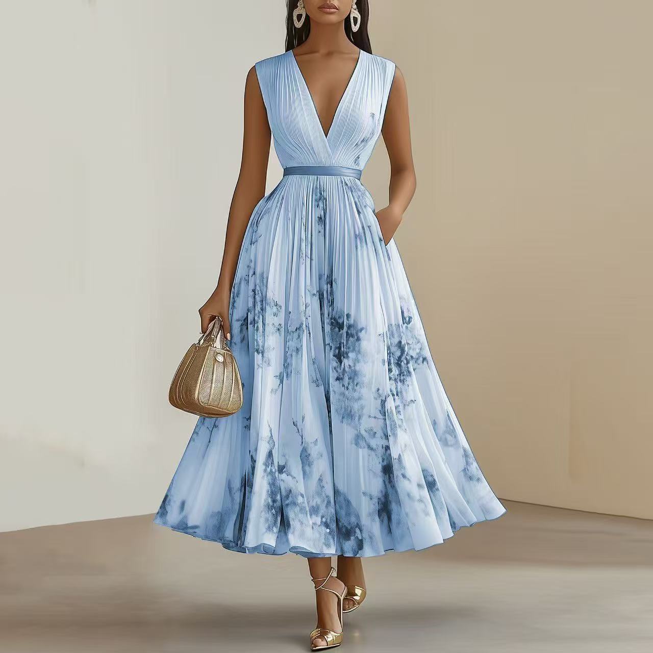 Woman wearing a blue tie-dye dress holding a gold handbag against a neutral background