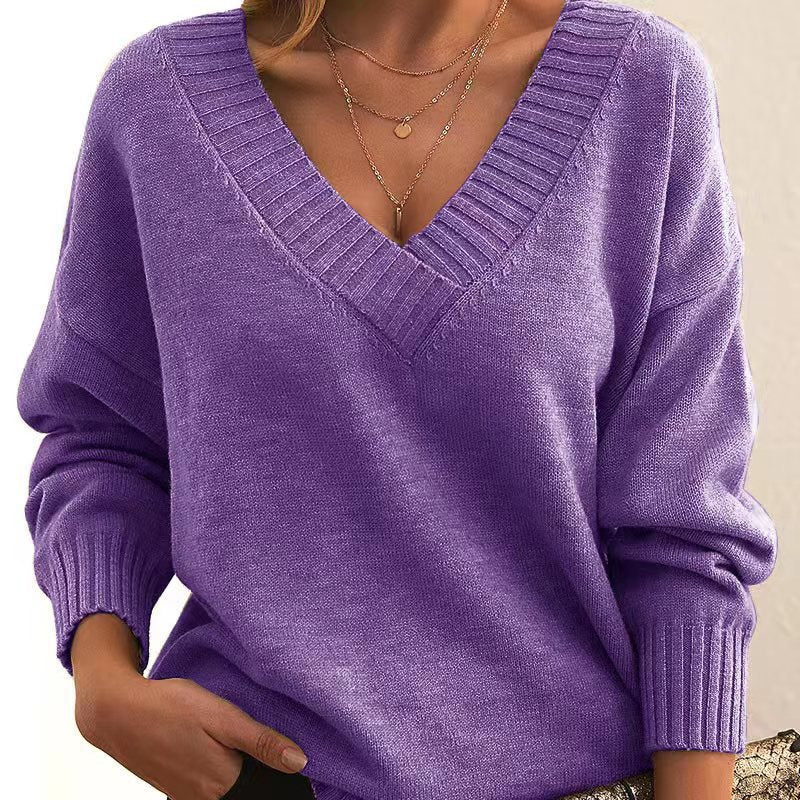 Purple sweater worn by a person on a beige background