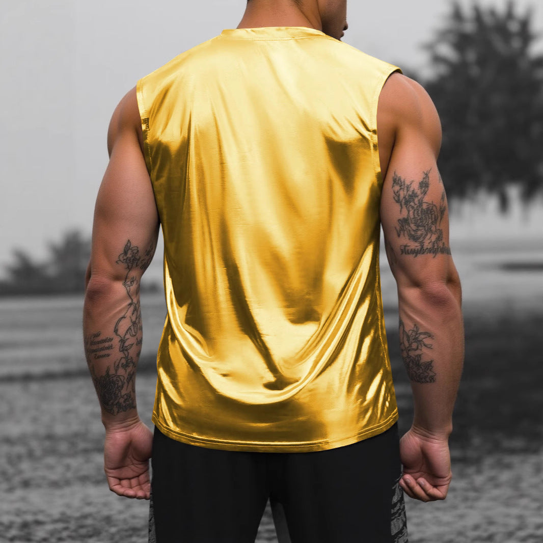 Person wearing a shiny gold tank top with tattoos on arms, standing outdoors.