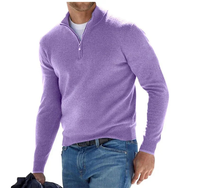 Man wearing a purple quarter-zip sweater and blue jeans on a white background