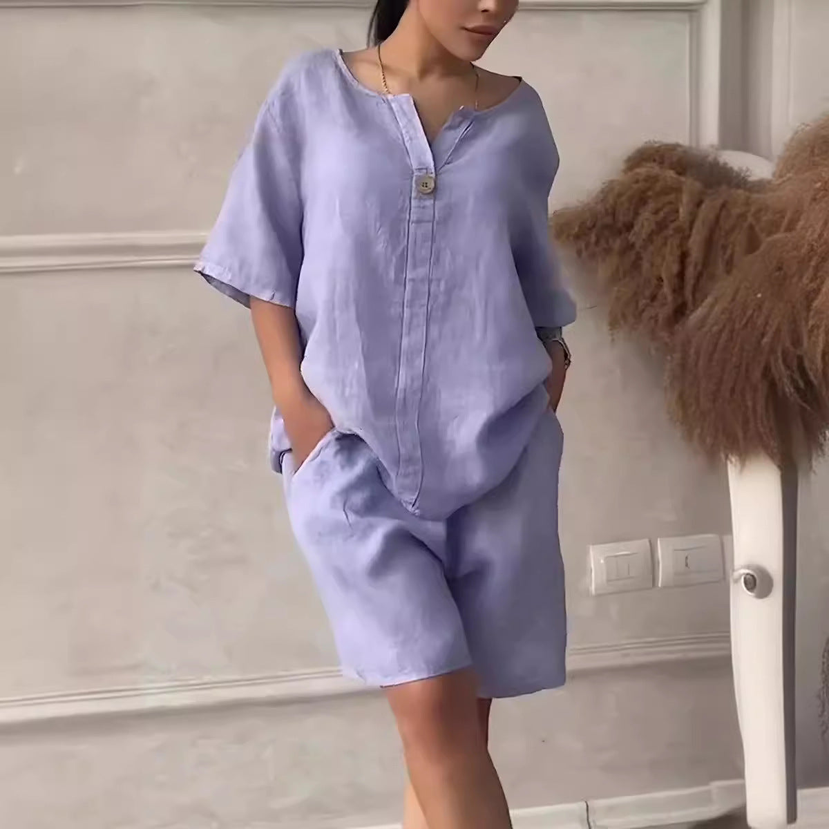 Person wearing a light purple outfit with a plain background