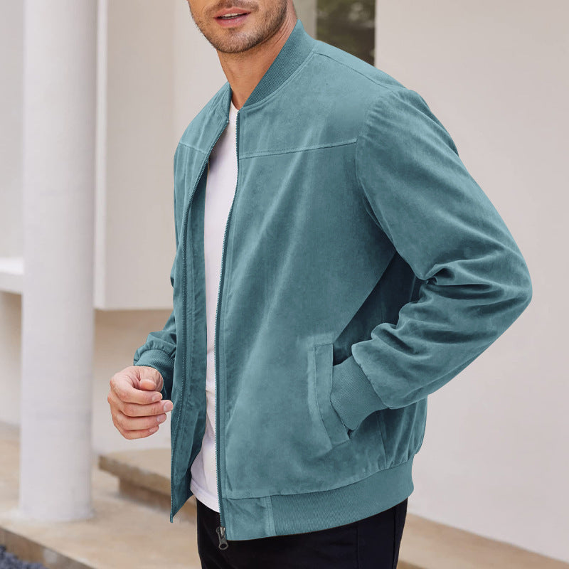 Man wearing a teal jacket indoors with a neutral background