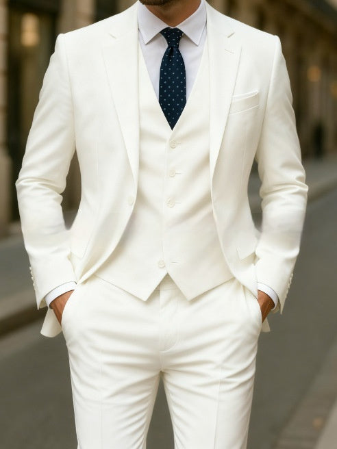 White suit with a blue tie worn by a person, blurred background