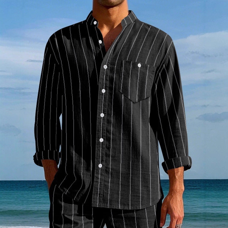 Person wearing a black pinstripe shirt on a beach with ocean and sky in the background