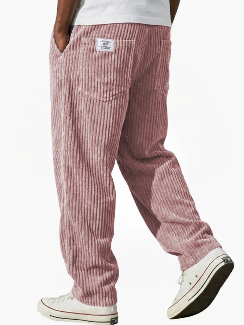 Red corduroy pants worn by a person on a white background